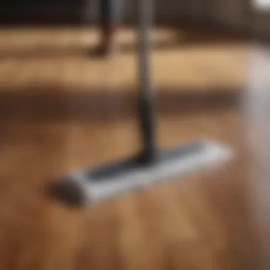 Close-up of a person using a microfiber mop on a wooden floor